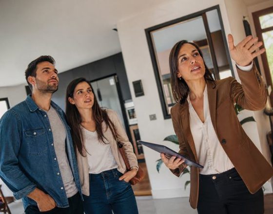 Una pareja visita una casa en venta junto a una corredora